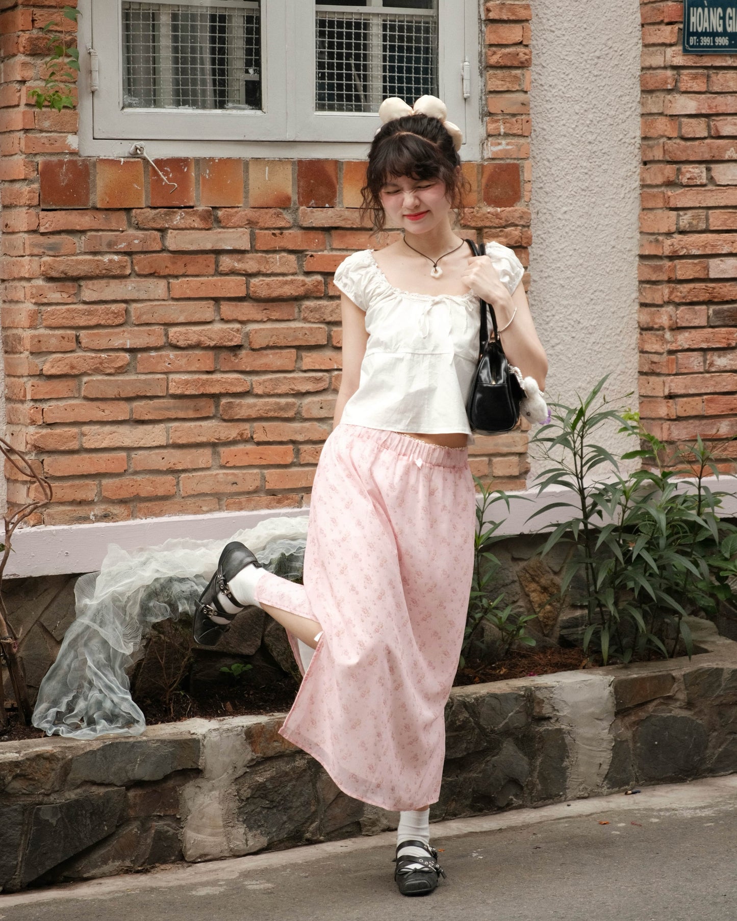 girl wearing cute pink skirt posing with one leg kicked up and happy scrunching face